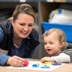 Young child making art with an adult